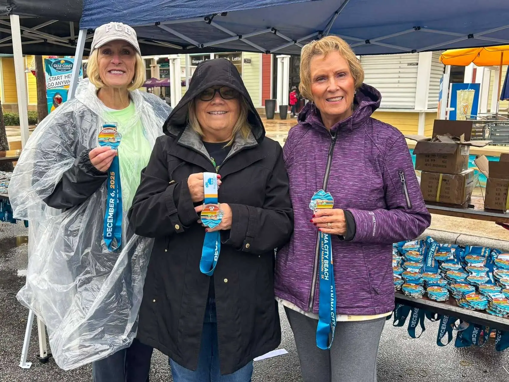 Volunteers handing out medals to participants at the 2025 Panama City Beach Marathon.